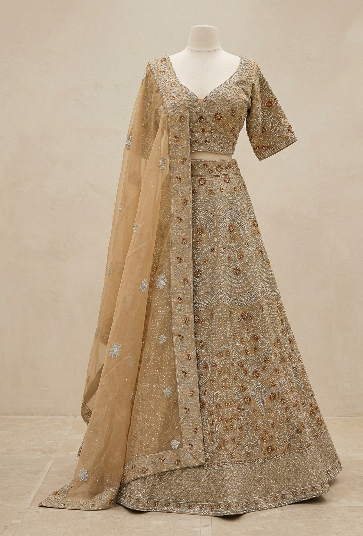 Full look: champagne gold lehenga with a fitted sweetheart-neckline blouse, wide flared skirt, and a soft net dupatta with an embroidered border