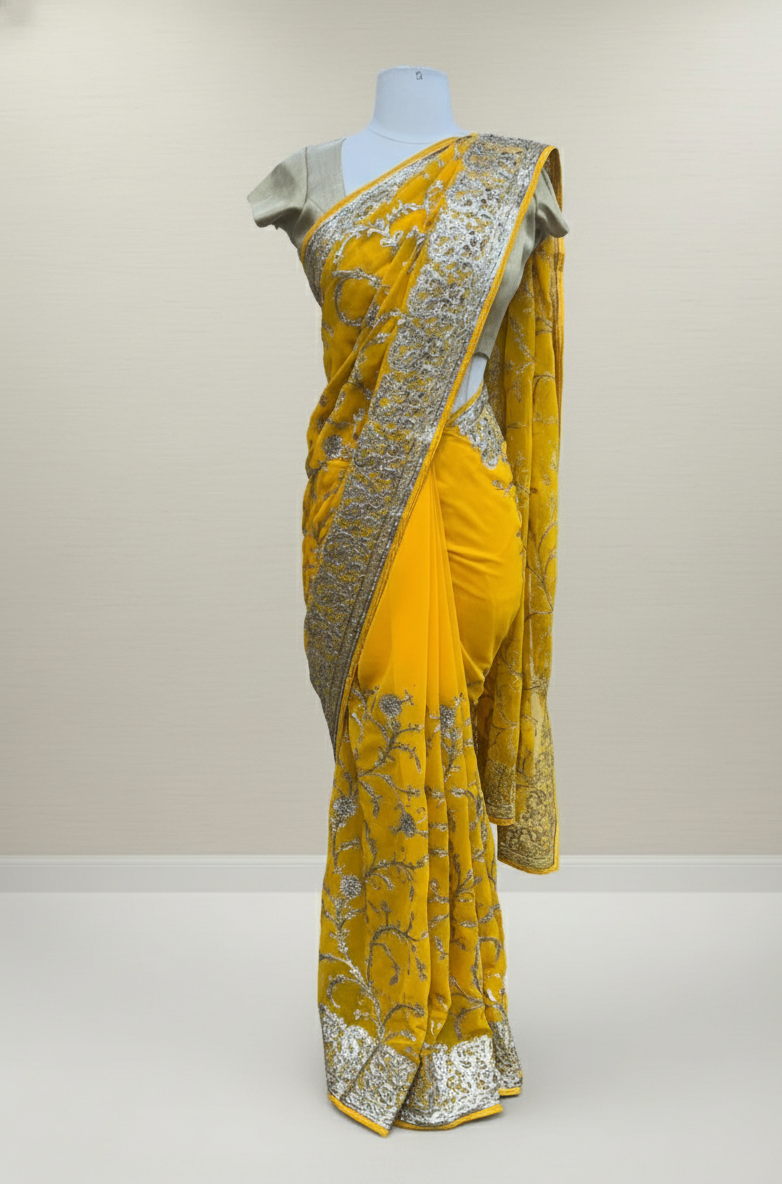 Detail of the detailed floral vines and a richly crafted border on this yellow saree