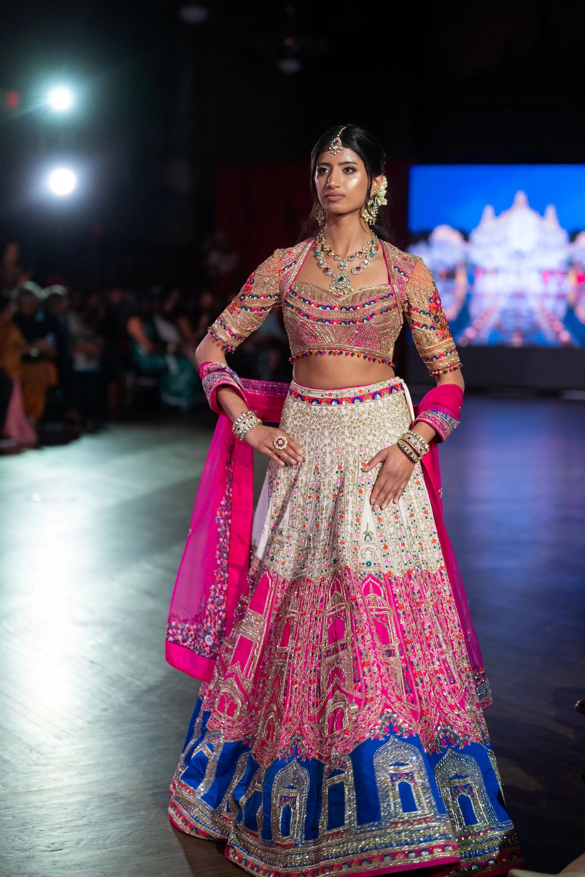 Banke Bihari Holi pink and ivory lehenga with a blue temple-arch border and magenta dupatta on the runway