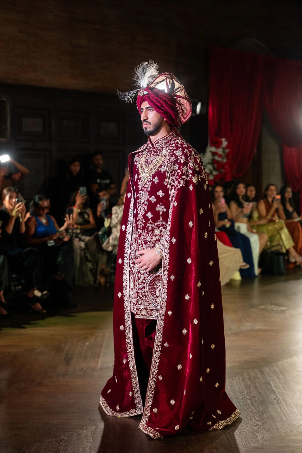 Three-quarter side view of the Belur Math maroon velvet cape and gold-embroidered sherwani