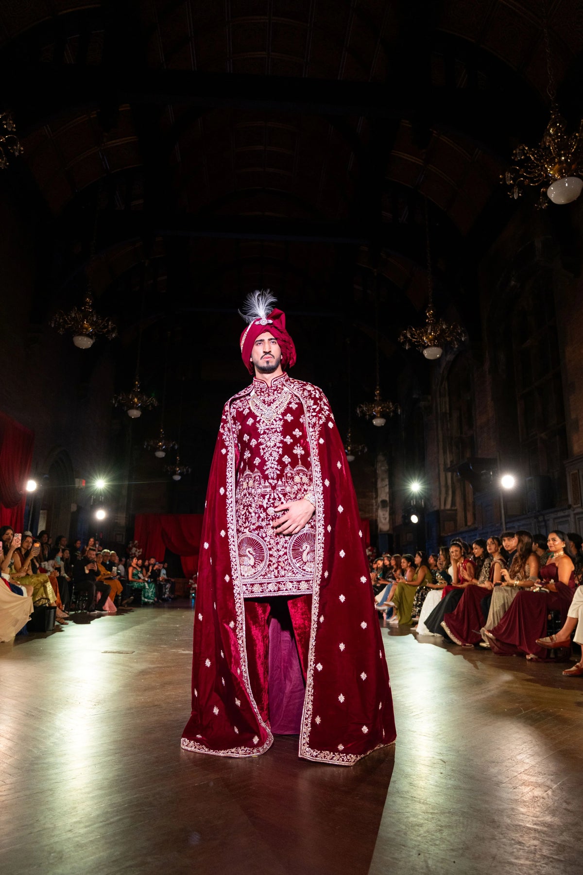Mid-distance front view of the Belur Math maroon velvet sherwani and cape on the runway