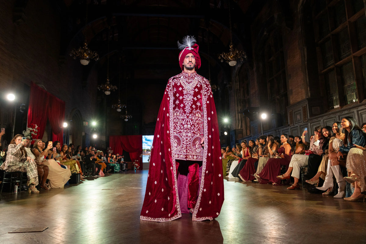 Wide runway view of the Belur Math maroon velvet sherwani with cape and feathered turban