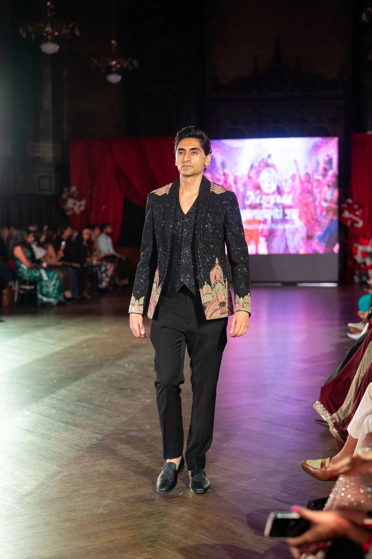 Man walking the runway in the Dakshineshwar Kali black embroidered jacket with black trousers