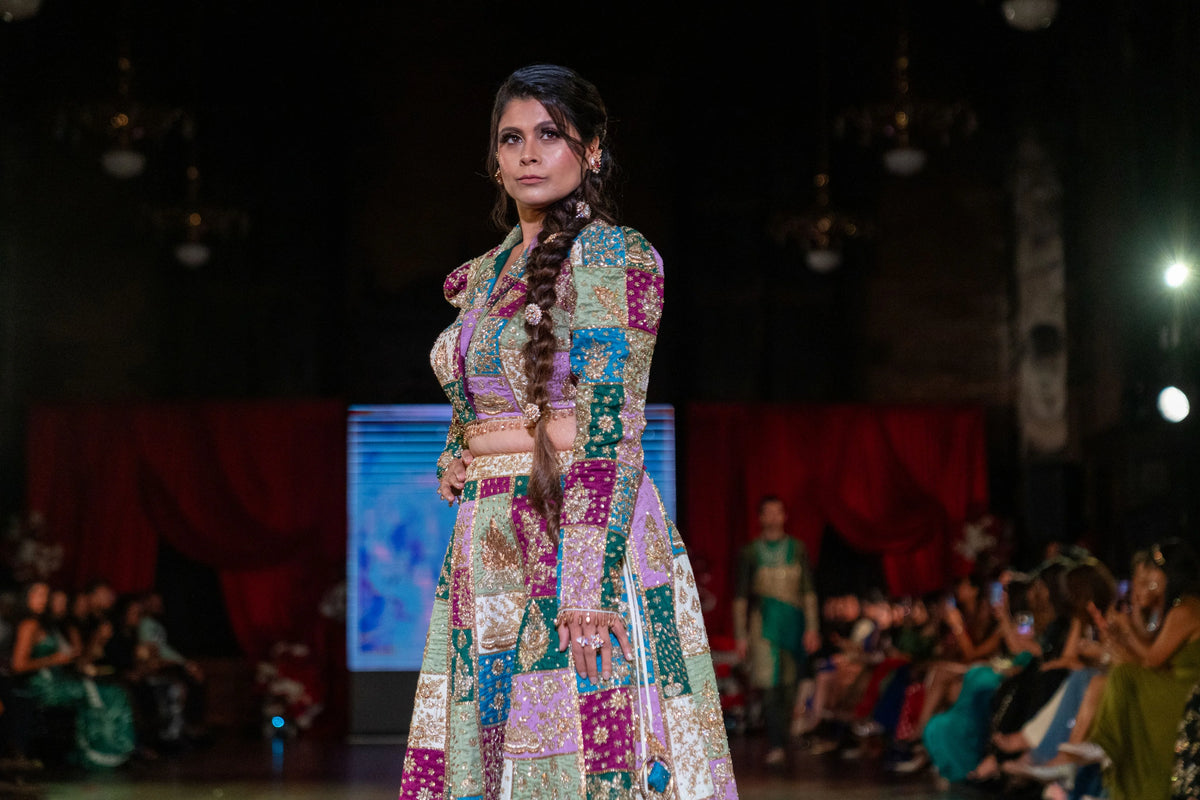 Distant runway view of the Holi patchwork lehenga set with audience seated beyond