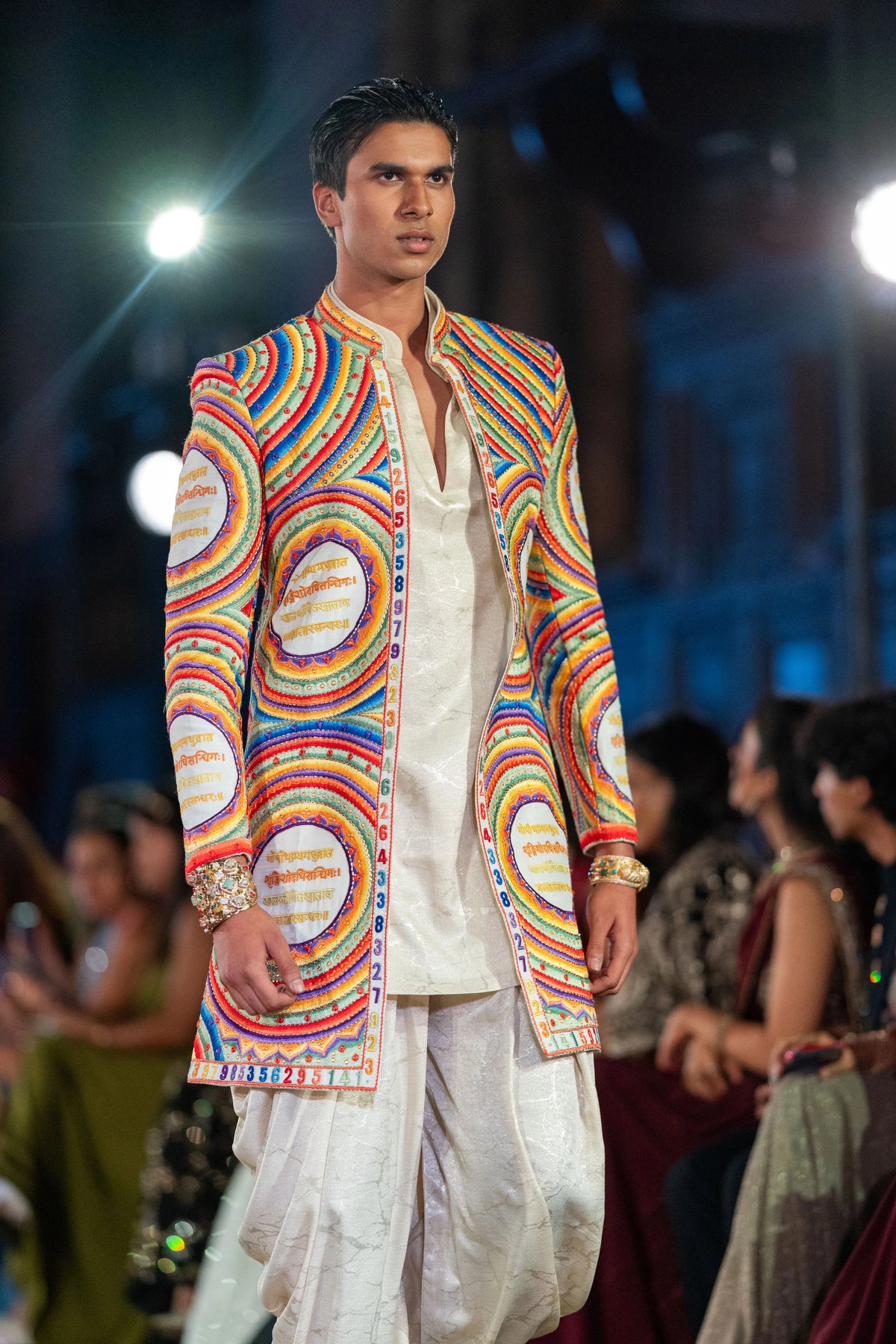 Katapayadi multicolor concentric-circle embroidered jacket over an ivory kurta and white dhoti pants on the runway