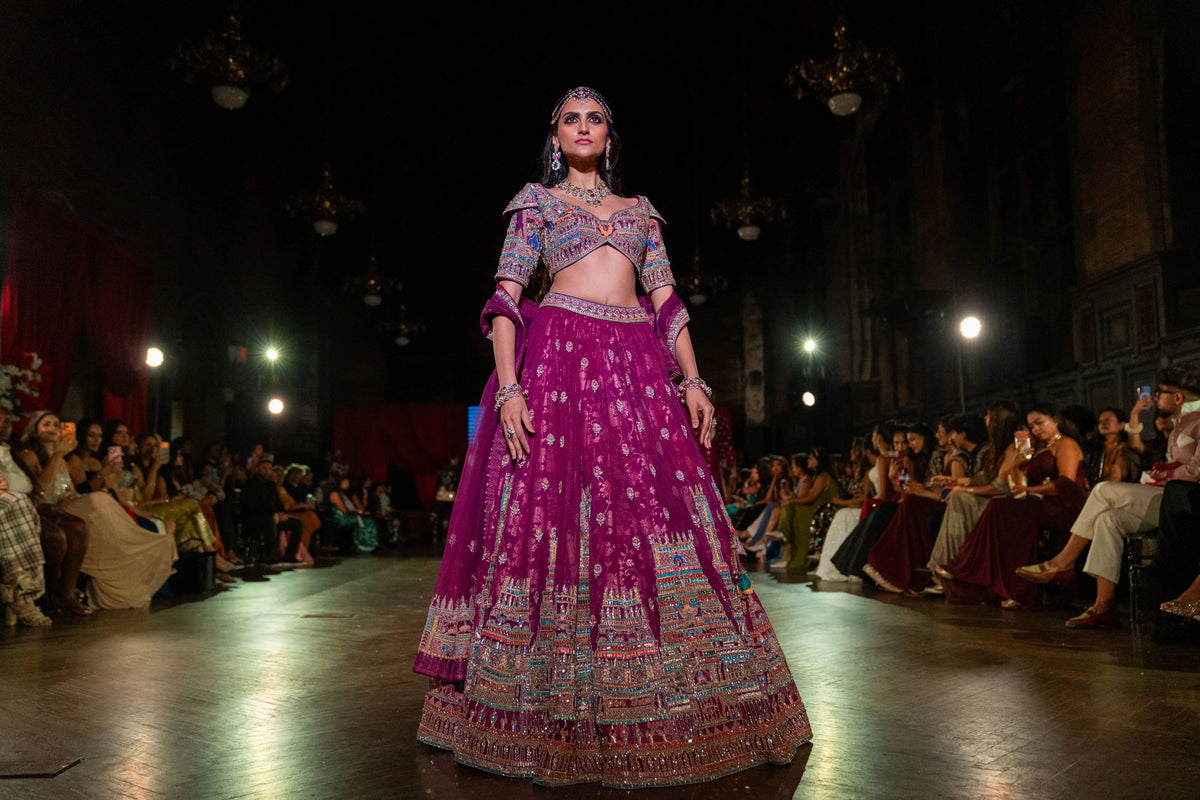Distant runway view of the Meenakshi Temple magenta lehenga set on the stage
