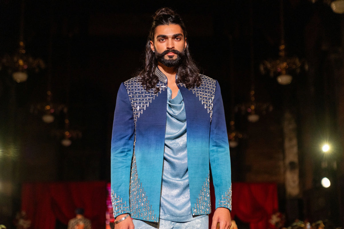 Half-length front view of the Meru Prastara blue ombre jacket with embroidered shoulders over a pale blue kurta