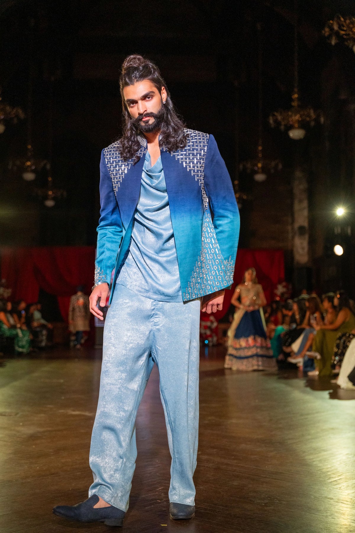 Full-length view of the Meru Prastara blue ombre jacket and wide-leg pale blue trousers mid-step on the runway