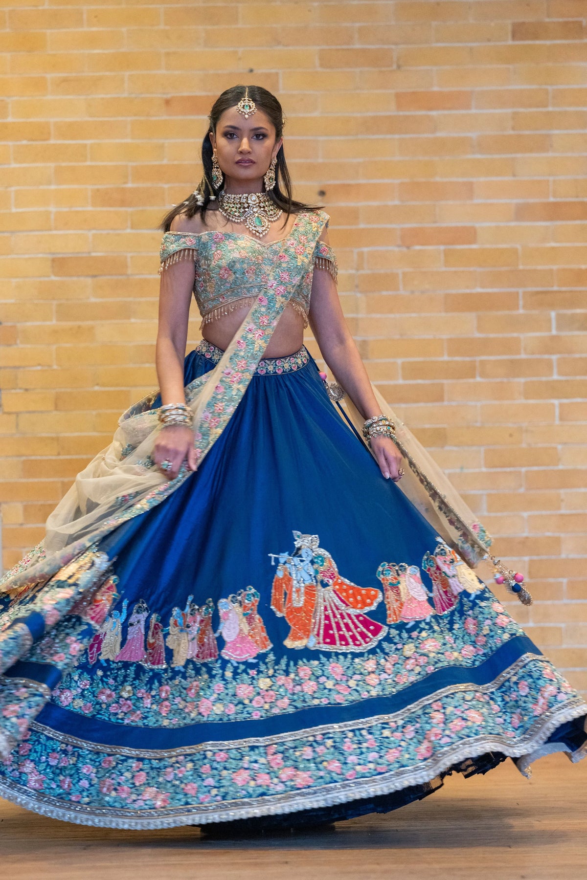 Raas Leela blue lehenga skirt flaring as the model spins in front of a brick wall