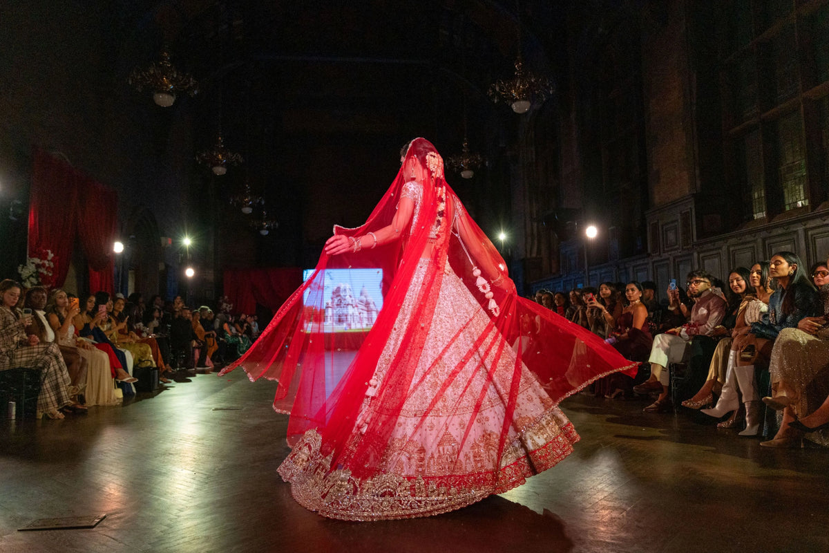 Wide runway shot of the Siddhivinayak lehenga with the red dupatta billowing behind the model