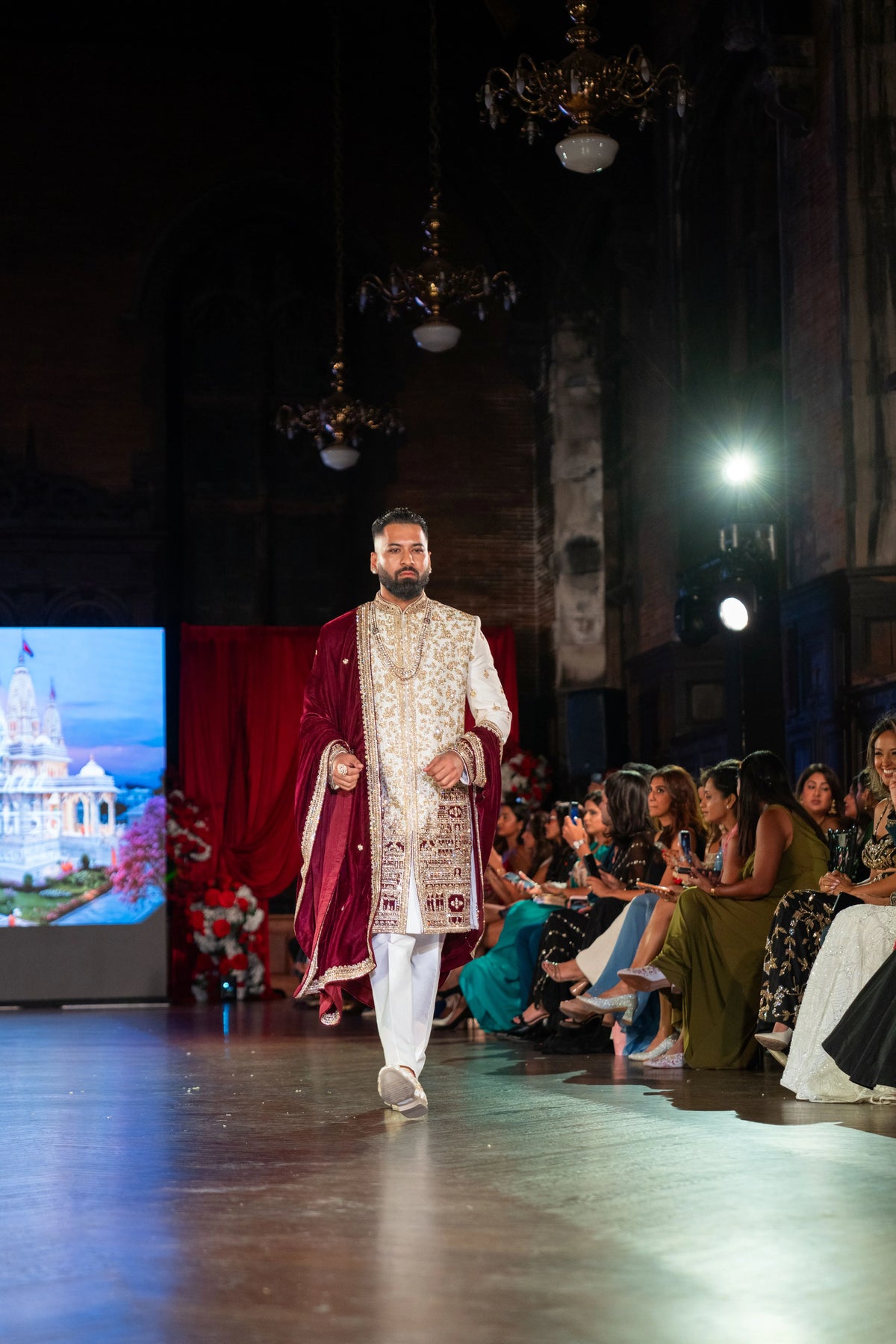 Distant runway view of the Venkateshwara ivory sherwani with a maroon velvet shawl