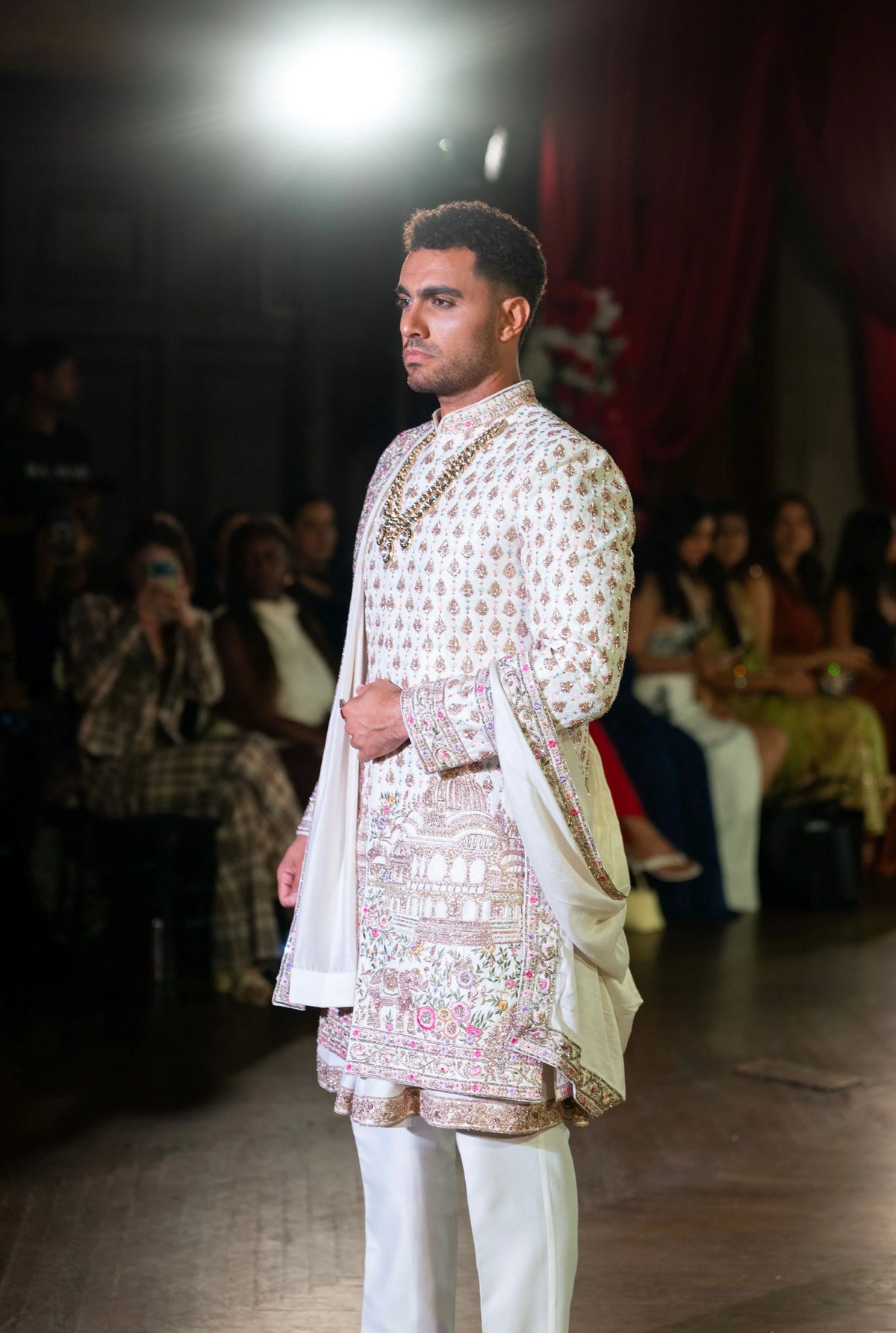 Side angle of the Vrindavan ivory and pink embroidered sherwani with white trousers on the runway